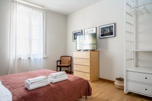 a bedroom with a bed with a television and towels at Officina7 Large in Parma