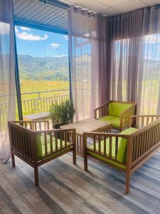 Pokój z 2 łóżkami i stołem oraz balkonem w obiekcie Ventosa HomeFarm - Venuestay w mieście Kon Von Kla