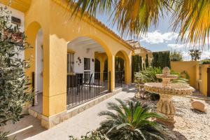 a yellow house with a courtyard with a fountain at Villa Sueño in Mazarrón
