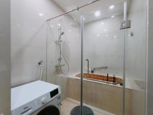 a bathroom with a shower and a washing machine at SuzhouGoethe Apartment in Suzhou