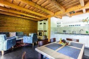 a kitchen and living room with a table and chairs at Rezort Drevenice Terchova in Terchová