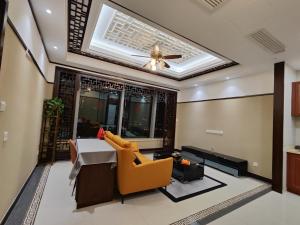 een woonkamer met een plafondventilator en een bank bij SuzhouGoethe Apartment in Suzhou