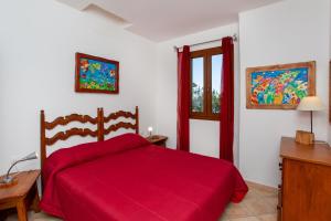 a bedroom with a red bed and a window at casa sulla spiaggia 2 in Orosei