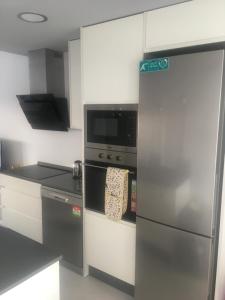 a kitchen with a stainless steel refrigerator and a microwave at Casa Escocesa in San Pedro del Pinatar