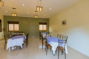 a dining room with tables and chairs with white table cloth at KAMI LUXURY APARTMENTS in Kigali