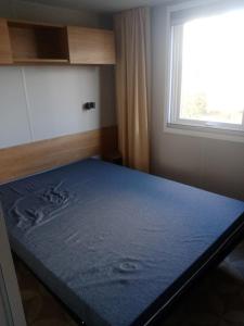 a bed in a room with a window at MOBIL HOME DU ROUTIER in Valras-Plage