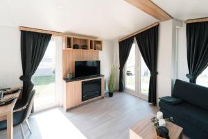 a living room with a couch and a tv at gemütliches voll ausgestattes Tiny House in Vilseck