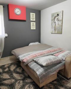 uma cama num quarto com um relógio na parede em Olivia's Loft House One em Ioannina