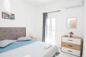 una camera con letto, cassettiera e finestra di Zervakis Apartments a Ferma