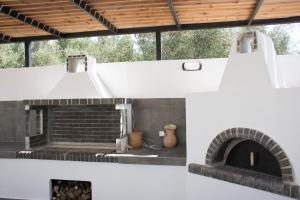 un forno in mattoni in una stanza bianca con soffitto di Zervakis Apartments a Ferma