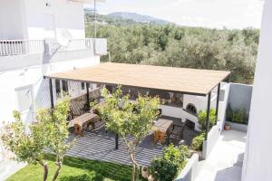 patio z krzesłami i stołami w budynku w obiekcie Zervakis Apartments w mieście Ferma