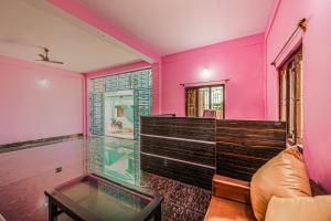 a living room with pink walls and a glass aquarium at Super OYO Kirti Inn in Puri