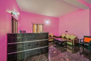 a living room with pink walls and a couch at Super OYO Kirti Inn in Puri