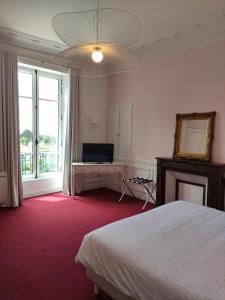 a bedroom with a bed and a flat screen tv at Domaine de La Gressière in La Bernerie-en-Retz