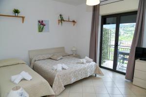 a bedroom with two beds and a balcony at B&B Damiani in Santa Maria di Castellabate +46 photos