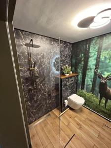 a bathroom with a shower with a painting of a deer at Appartement fliegender Hirsch in Bäk