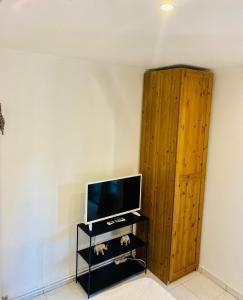 a living room with a tv and a wooden cabinet at Appartement in Flayosc