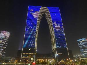 un edificio alto con luces azules por la noche en SuzhouGoethe Apartment, en Suzhou