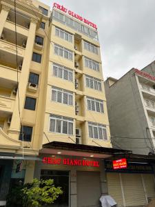 un gran edificio amarillo con un cartel. en Châu Giang Hotel Cửa Lò, en Cửa Lô