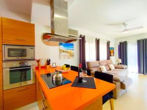 a kitchen with an orange counter top and a living room at Lemon Terraced House in Playa del Ingles