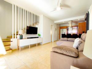 een woonkamer met een bank en een tv bij Lemon Terraced House in Playa del Inglés