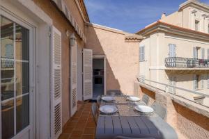 patio con mesa y sillas en el balcón en Alla Casa - Appt pour 6 avec terrasse en Aregno