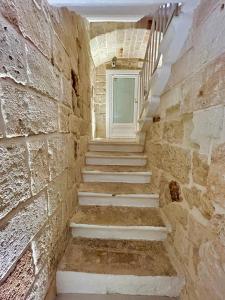 a staircase in a stone building with a window at La Vitagira in Monopoli