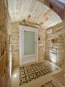 een badkamer met een raam in een stenen muur bij La Vitagira in Monopoli
