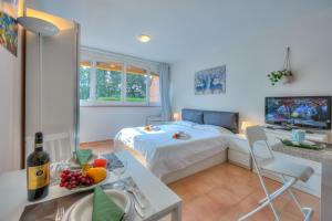 a living room with a bed and a table with a bowl of fruit at Apartments Gelsomino, Orchidea and Magnolia in Castagnola