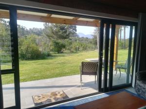 a sliding glass door with a view of a patio at Beessential Farm in The Crags