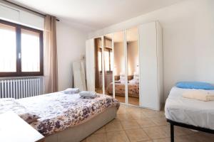 een slaapkamer met 2 bedden en een grote spiegel bij Casa Belvedere in Foiano della Chiana