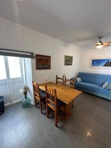 uma sala de estar com uma mesa de madeira e um sofá azul em Apartment in old town with roof terrace and fibre, Tarifa em Tarifa