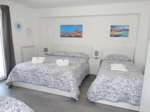 two beds in a room with white walls at Villa Milicia in Altavilla Milicia