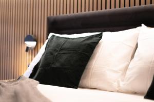 un letto con cuscini bianchi e neri di Hotel Central a Engelberg Altre 51 foto