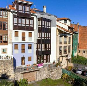 ein großes weißes Gebäude vor einigen Gebäuden in der Unterkunft Apartamentos Camparina in Llanes