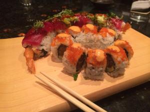 a plate of sushi with chopsticks on a wooden board at Alyeska Resort in Girdwood