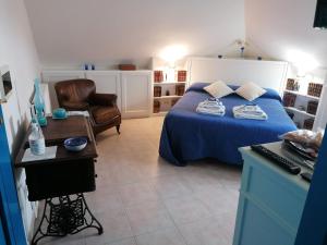 1 dormitorio con 1 cama azul y 1 silla en Coros, en Nuoro