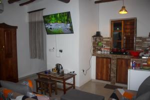 a living room with a tv hanging on the wall at A Villa Sunshine house Zanzibar in Jambiani