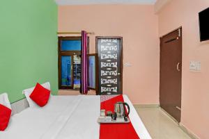 Cette chambre comprend un lit aux murs rouges et verts. dans l'établissement Flagship Second Home Guest House Near Omaxe Celebration Mall, à Gurgaon
