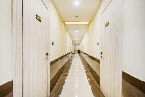 długi korytarz w budynku z drewnianymi drzwiami w obiekcie Super OYO Townhouse Hotel Gokul Regency Near Dum Dum Metro Station w mieście Dum Dum
