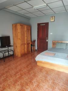 a bedroom with a bed and a flat screen tv at Soi 5 Apartment in Pattaya