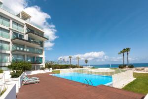 un edificio con piscina junto al océano en Apartment Marisol - Beachfront, en Protaras
