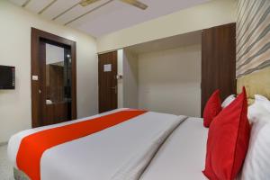 a bedroom with a large bed with red pillows at Sunshine Inn Near Pune Railway Station in Pune