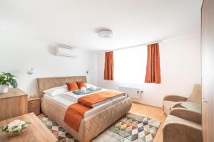 - une chambre avec un lit et un canapé dans l'établissement Topáz Apartmanházak Keszthely, à Keszthely