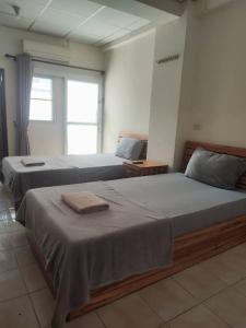 two beds sitting next to each other in a bedroom at Soi 5 Apartment in Pattaya