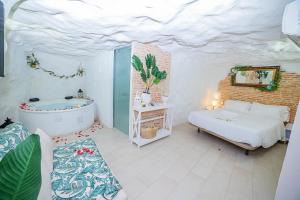 1 dormitorio con 1 cama y bañera en una habitación en Casa Rural Las Colmenas, en Alcalá del Júcar