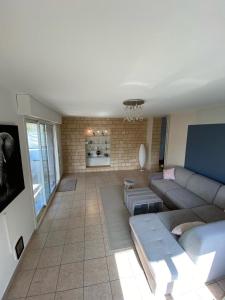 ein Wohnzimmer mit einem Sofa und einem TV in der Unterkunft Le relais des trois châteaux in Flixecourt