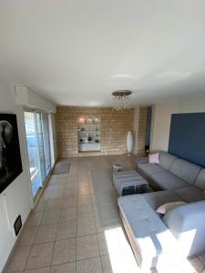 a living room with a couch and a tv at Le relais des trois châteaux in Flixecourt