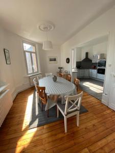 eine Küche und ein Esszimmer mit einem Tisch und Stühlen in der Unterkunft Le relais des trois châteaux in Flixecourt