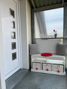 une plaque rouge assise sur un banc à côté d'une porte dans l'établissement Villa Relax KomfortLak, à Gárdony